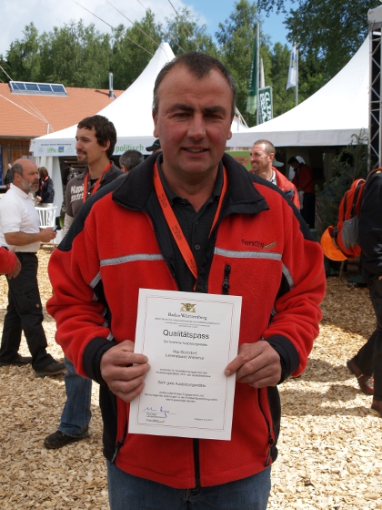 Stolz präsentiert Forstwirtschaftsmeister Werner Metzler den Qualitätspass